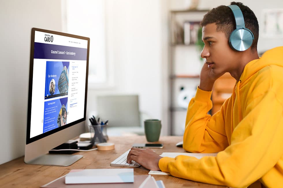 teen boy in a yellow jacket watching the conquering cars curriculum